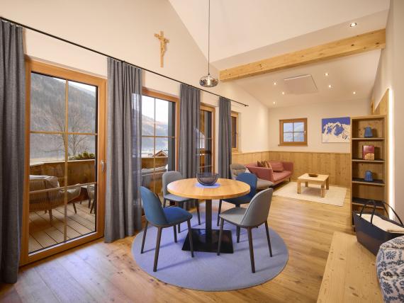 Wohnzimmer im Hochfeldhof mit Holzmöbeln und großer Fensterfront