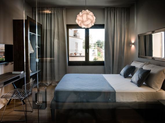 Camera matrimoniale del Teku Boutique Hotel con finestra, letto, scrivania e TV