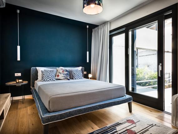 Camera da letto del Teku Boutique Hotel con letto matrimoniale e finestre sul balcone