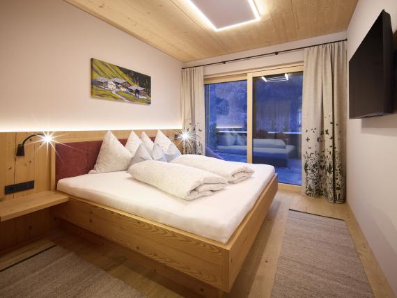 Gemütliches Schlafzimmer im Hochfeldhof mit Holzmöbeln und Balkon