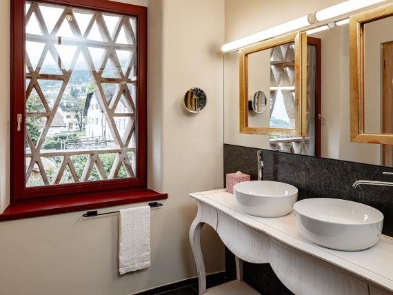 Modernes Badezimmer mit zwei Waschbecken und Fenster bei Castel Sallegg