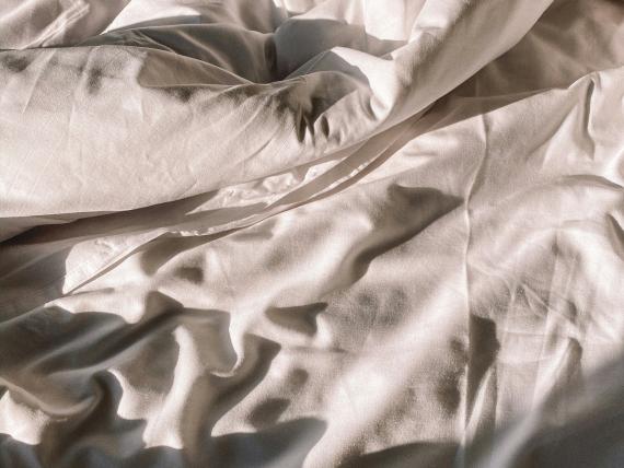 Verwobene weiße Bettwäsche im Hotel Aurora