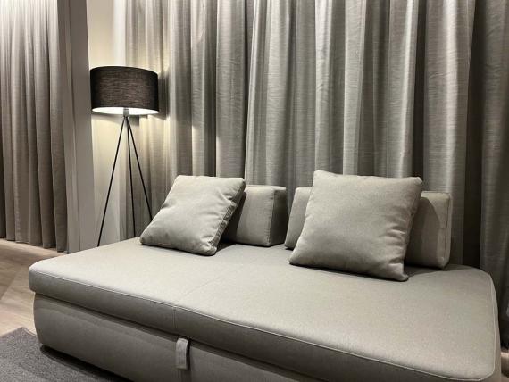 Poltrona grigia moderna con cuscini e lampada da terra in Evangelisti Palace Suite & Apartments