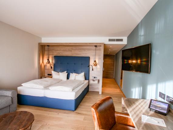 Modernes Hotelzimmer im Pfalzblick Wald Spa Resort mit Doppelbett und Schreibtisch