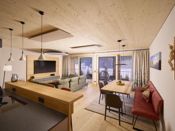 Helles Wohnzimmer und Essbereich im Hochfeldhof mit Holzdecke und Balkon