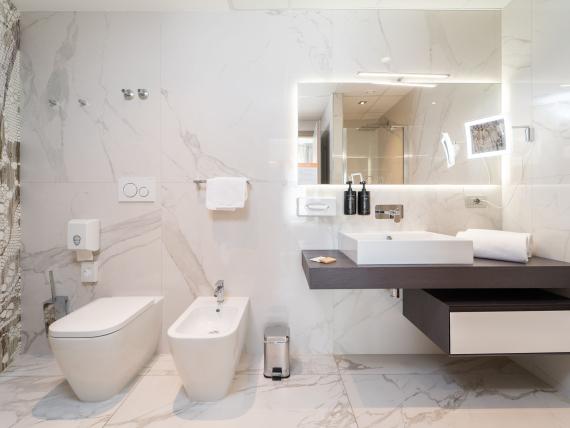 Bagno moderno al Bibione Palace Hotel con WC, bidet e specchio illuminato