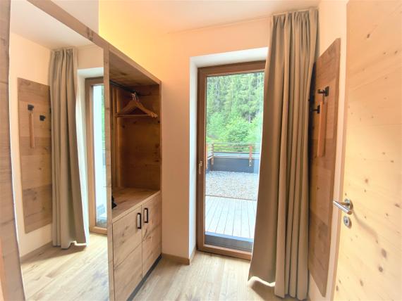 Eingangsbereich mit Garderobe und Blick nach draußen im Naturhotel Die Waldruhe