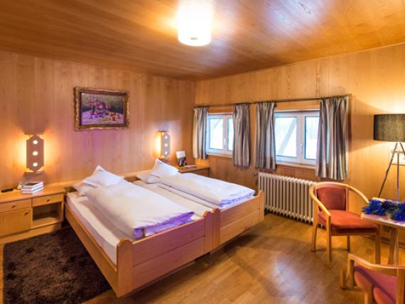 Gemütliches Zimmer im Parc Hotel Florian mit Holzwänden und Doppelbett