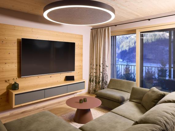 Wohnzimmer mit großem TV, Couch und Balkon bei Hochfeldhof