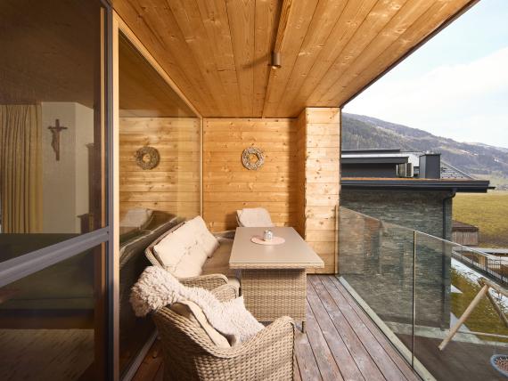 Balkon mit Holzwänden und Sitzbereich im Hochfeldhof mit Bergblick