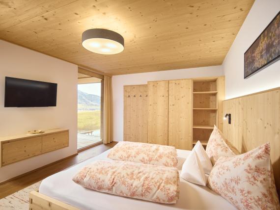 Schlafzimmer im Hochfeldhof mit Holzdecke und großer Fensterfront