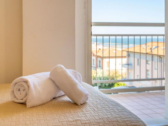 Vista dalla camera Le Rose Nuove Viserba con asciugamani bianchi e balcone sulla città