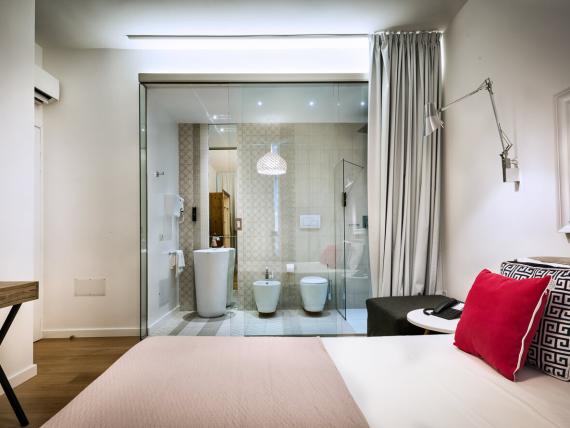 Camera del Teku Boutique Hotel con letto e bagno dietro una parete di vetro