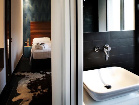 Area spa moderna con lavabo e camera da letto nel Q Hotel