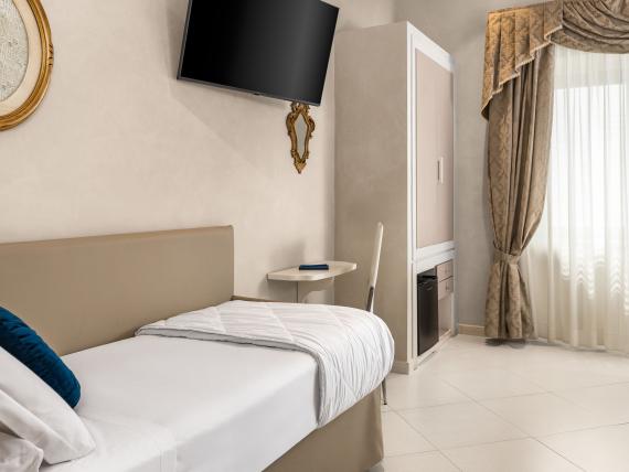 Camera singola moderna all'Hotel Regina Caserta con TV e finestra con tende