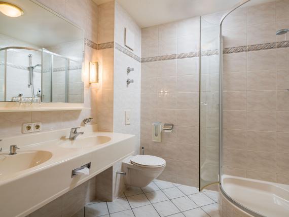 Modernes Badezimmer mit Doppelwaschbecken, Dusche und Toilette im Hammerhof Bodenmais