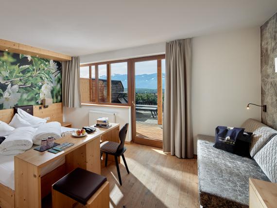 Zimmer im Naturhotel Die Waldruhe mit Bergblick und moderner Holzeinrichtung