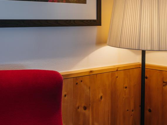 Roter Sessel und Stehlampe in einem Zimmer im Hotel Aurora