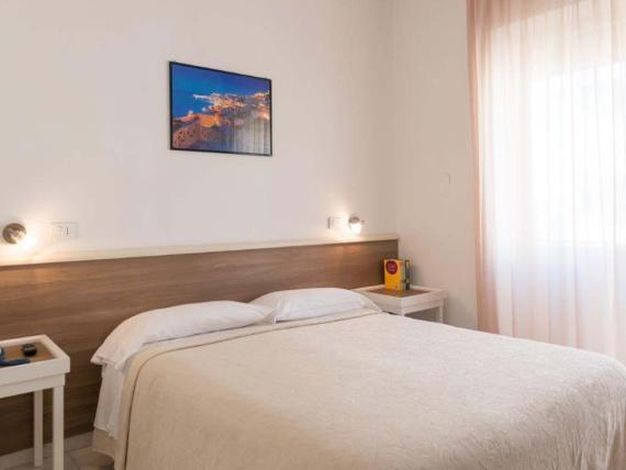 Camera matrimoniale semplice all'Hotel Viola Gaeta con testata in legno e tenda chiara