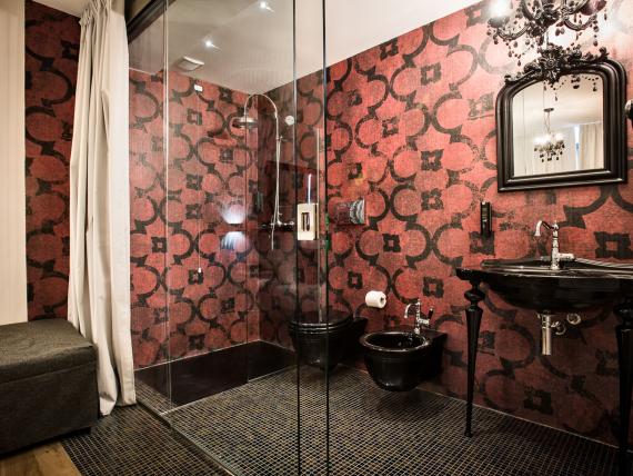Bagno del Teku Boutique Hotel con doccia in vetro e lavabo nero
