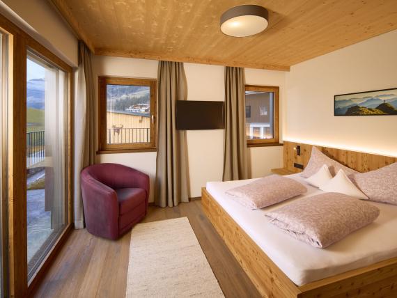 Helles Schlafzimmer im Hochfeldhof mit Bergblick, Holzdecke und gemütlichem Sessel
