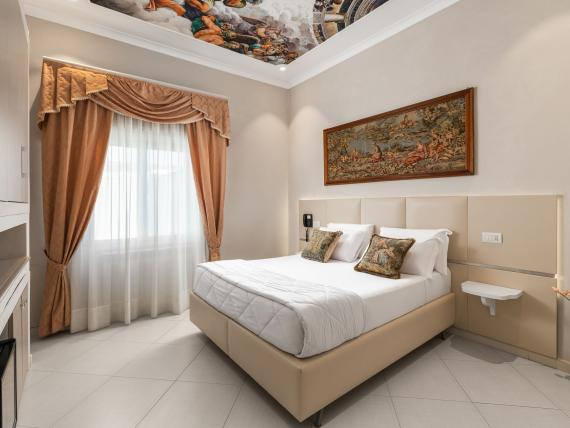 Camera dell'Hotel Regina Caserta con letto matrimoniale, quadro e tende