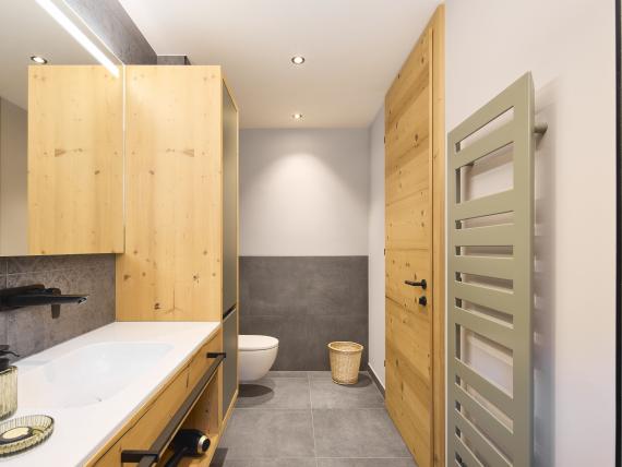 Modernes Badezimmer im Hochfeldhof mit Holzschränken und grauen Fliesen