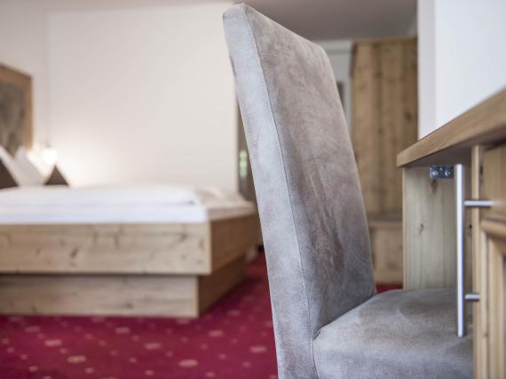 Stuhl und Bett in einem Zimmer im Hotel Waldsee mit rotem Teppich