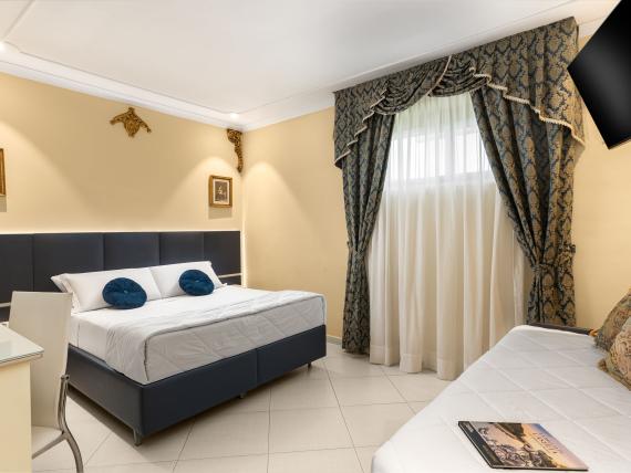 Camera elegante all'Hotel Regina Caserta con letto matrimoniale e divano