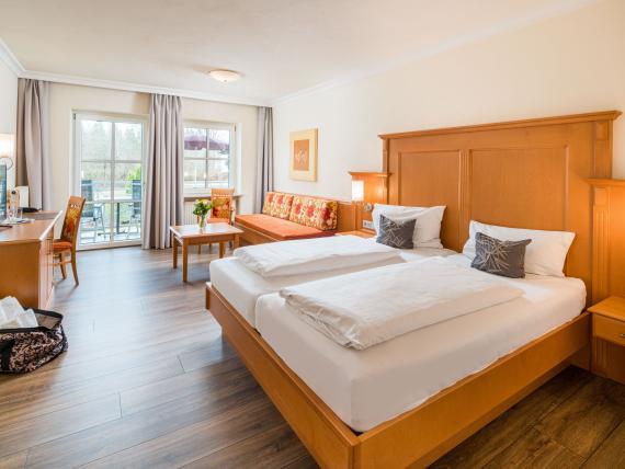 Helles Hotelzimmer mit Doppelbett und Balkon im Hammerhof Bodenmais