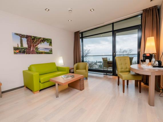 Gemütlicher Wohnbereich im Parkhotel St. Leonhard Überlingen mit grünem Sofa und Meerblick