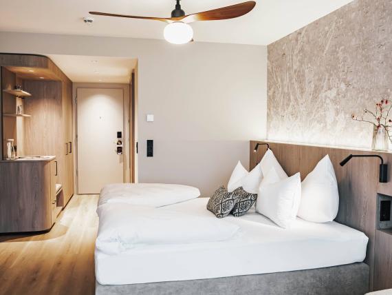 Modern room at Krumers Alpin with double bed and wooden ceiling fan