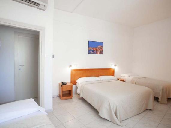 Camera luminosa con letto matrimoniale e letti singoli all'Hotel Viola Gaeta