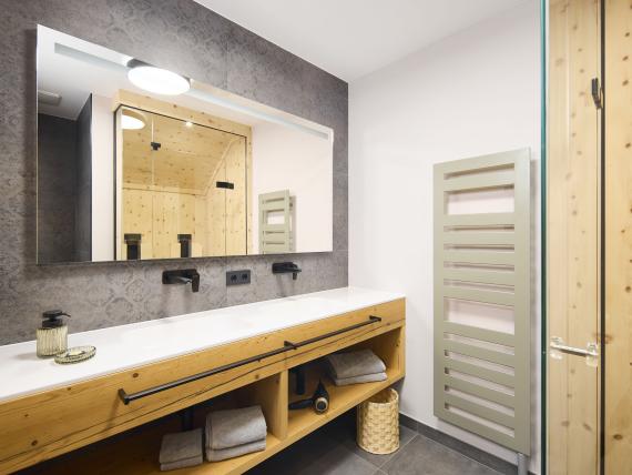 Modernes Badezimmer mit Holzablage und Spiegel im Hochfeldhof