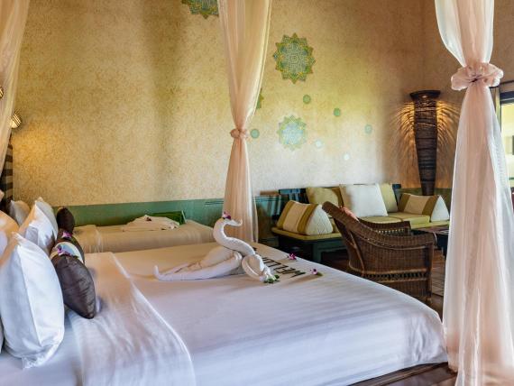 Relaxing room at The Mangosteen Ayurveda & Wellness Resort with draped curtains and cozy seating