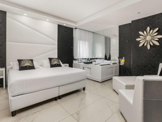 Camera elegante con letto bianco al Reggia Suite Spa Hotel