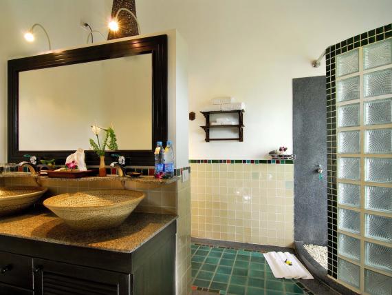 Bathroom with twin sinks and glass tile shower at The Mangosteen Ayurveda & Wellness Resort