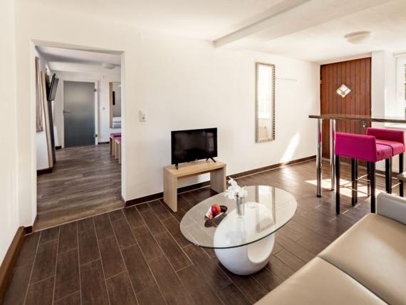 Gemütlicher Wohnbereich im Burghotel Staufeneck mit TV und moderner Einrichtung