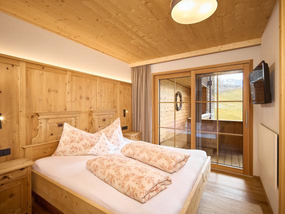 Gemütliches Schlafzimmer im Hochfeldhof mit Holzwänden und Balkon