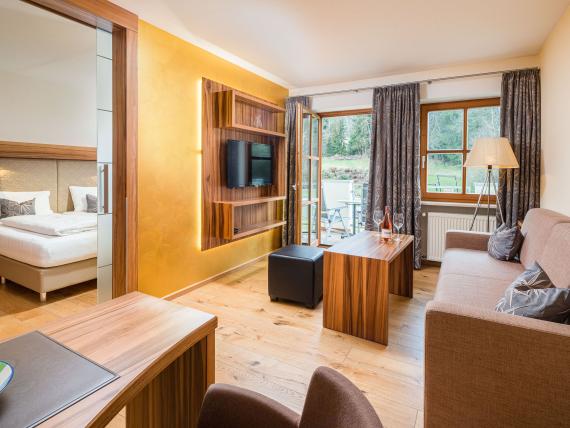 Modern eingerichtetes Wohnzimmer mit Blick auf Schlafzimmer im Hammerhof Bodenmais