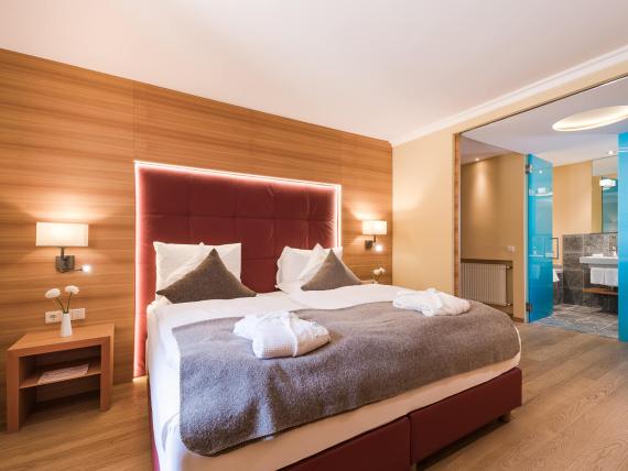 Modernes Hotelzimmer im Hotel Mignon Meran Park & Spa mit Doppelbett und Bad