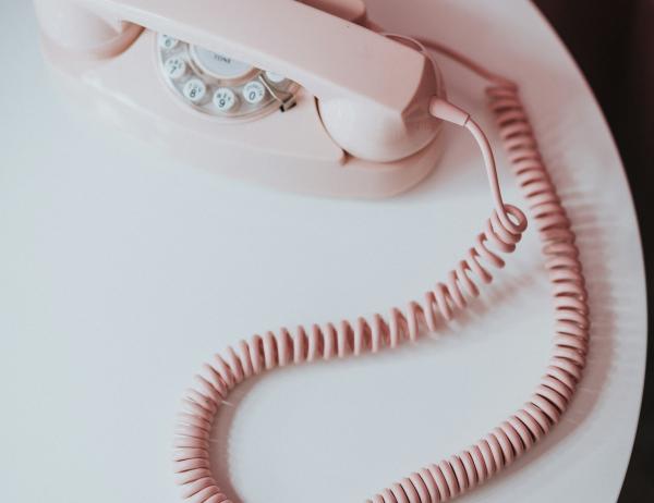 Pink rotary phone with Glockna on white round table