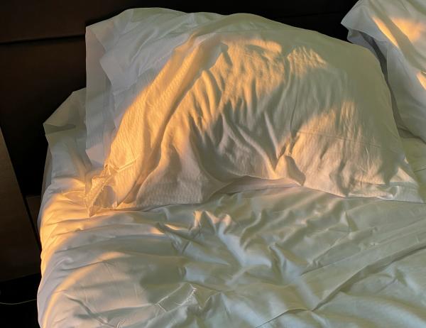 White pillow and bedding with sunlight in Glockna hotel room
