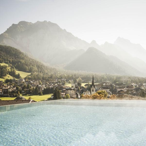 Blick auf Excelsior Dolomites Life Resort mit Infinity-Pool und Bergpanorama
