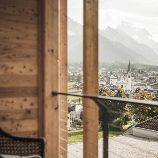 Blick vom Balkon des Excelsior Dolomites Life Resort auf Dorf und Dolomiten