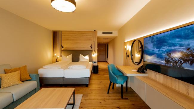Modernes Zimmer im Pfalzblick Wald Spa Resort mit Doppelbett und Sitzbereich