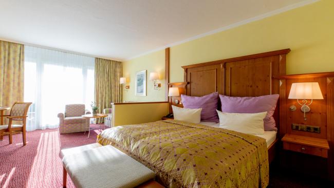 Komfortables Zimmer im Pfalzblick Wald Spa Resort mit großem Bett und Sitzbereich