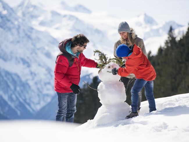Drei Gäste sitzen vor einer Hütte im Hotel Jagdhof Pfurtscheller Alpenblick