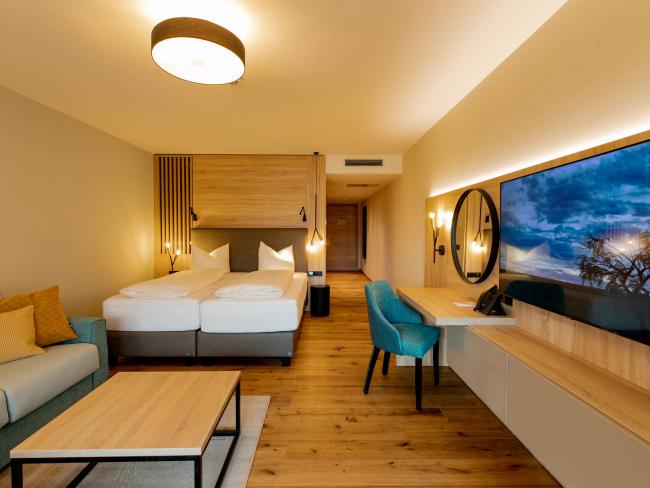 Modernes Zimmer im Pfalzblick Wald Spa Resort mit Doppelbett und Sitzbereich