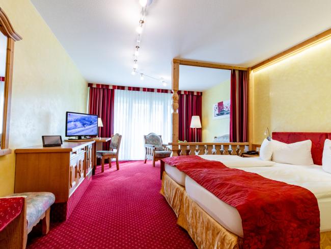 Gemütliches Zimmer im Pfalzblick Wald Spa Resort mit Doppelbett und TV